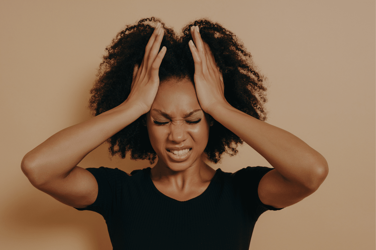 Person experiencing stress and tension before a self-care treatment at A Moment’s Peace